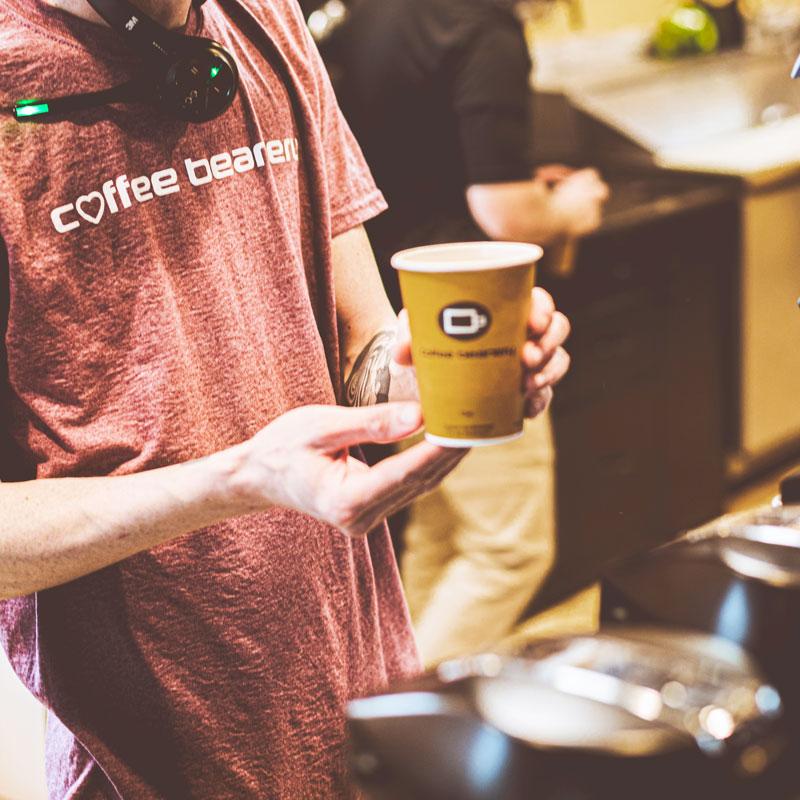 Image of Coffee Beanery Employee Holding a Coffee Beanery Cup