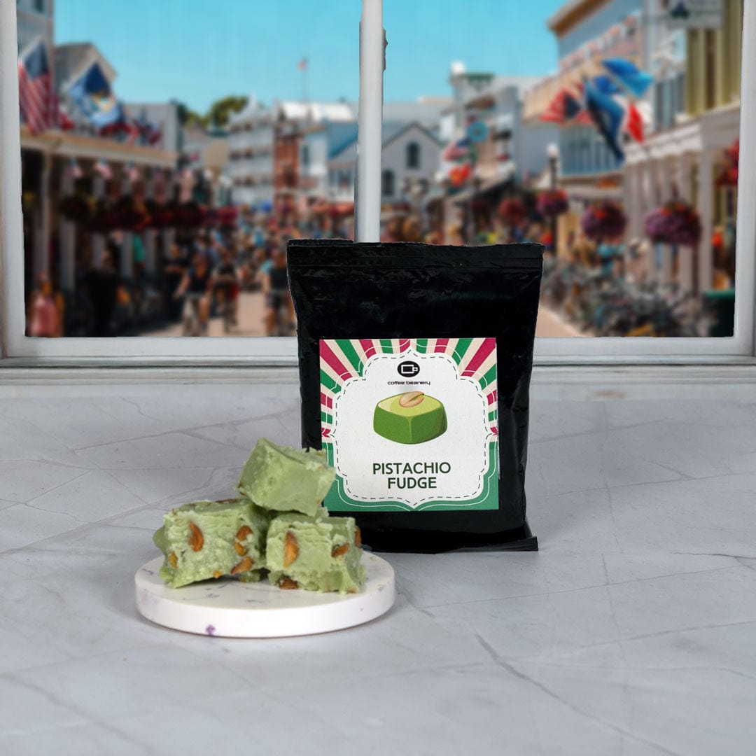 Pistachio fudge with a black bag labeled 'Pistachio Fudge' on a white surface with a cityscape background.